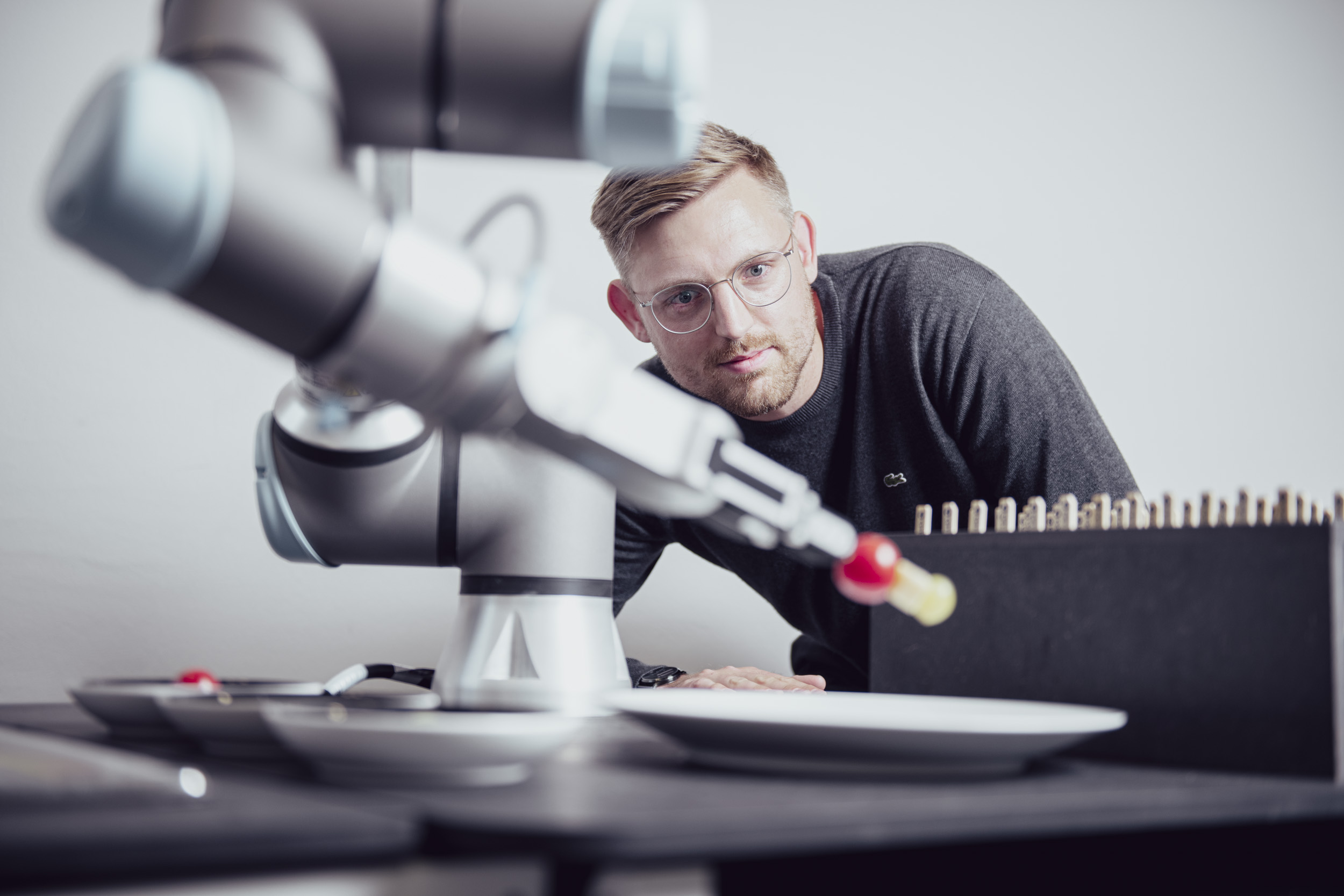 A robotic arm with a researcher observing it