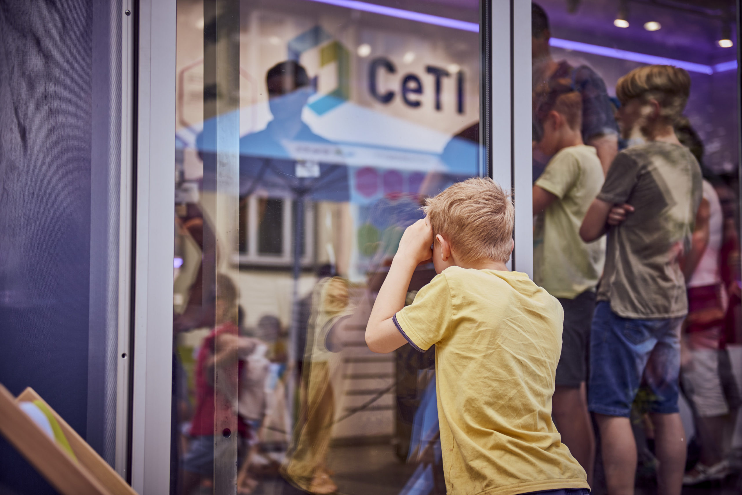 Image of a child looking through the glass inside the CeTI exhibition container