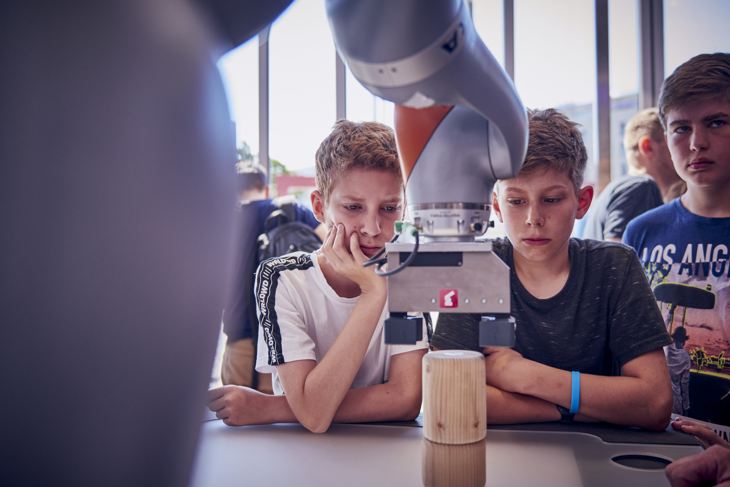 Image of children watching the operation of a robotic arm