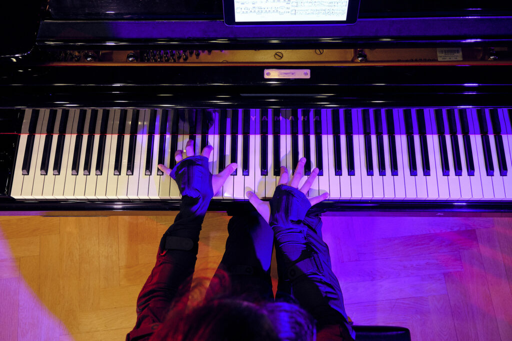 Overhead picture of a person playing the piano while their movement is tracked