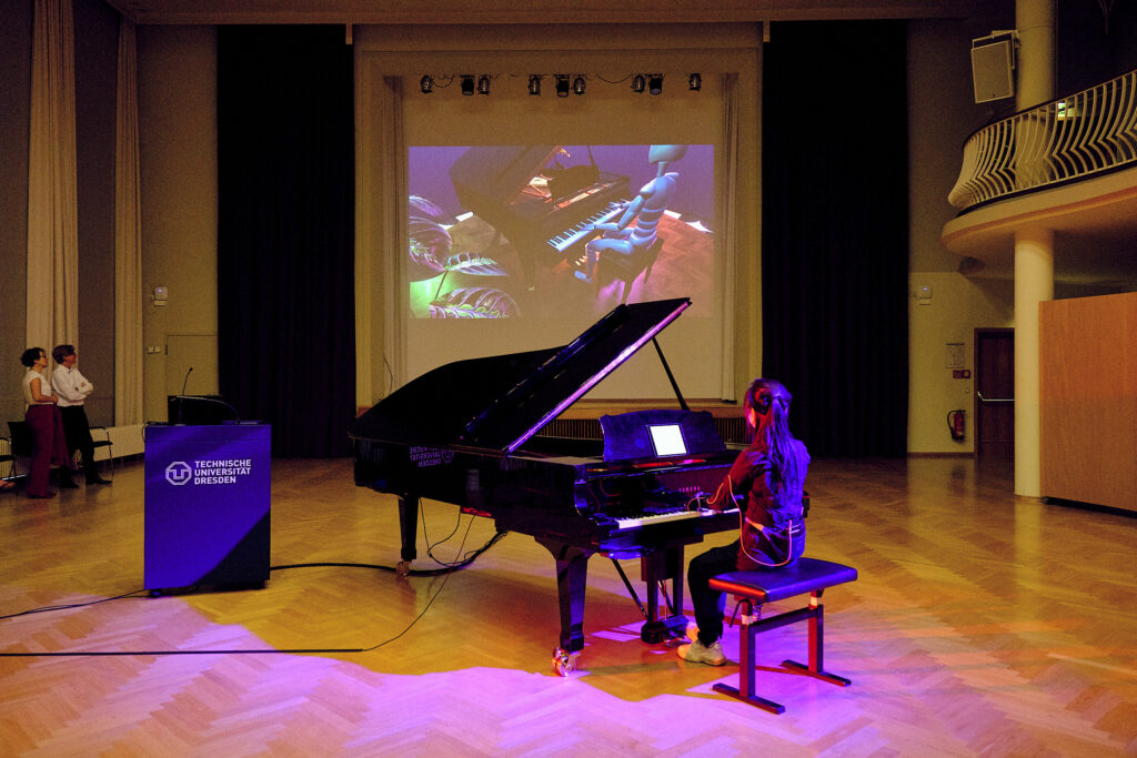 A person playing a grand piano with their digital avatar being projected onto a wall