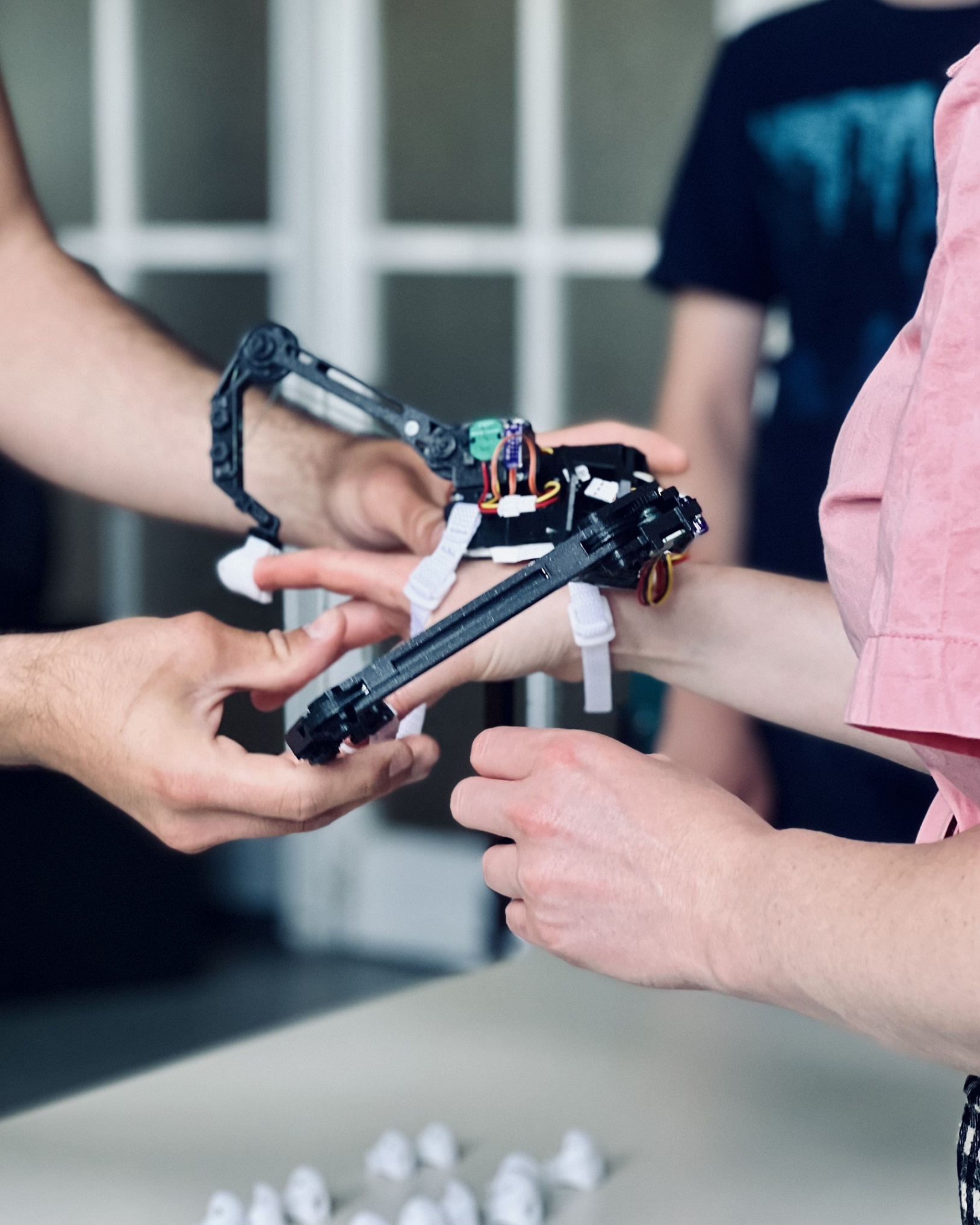 Image of a person helping another person to put on a robotic hand
