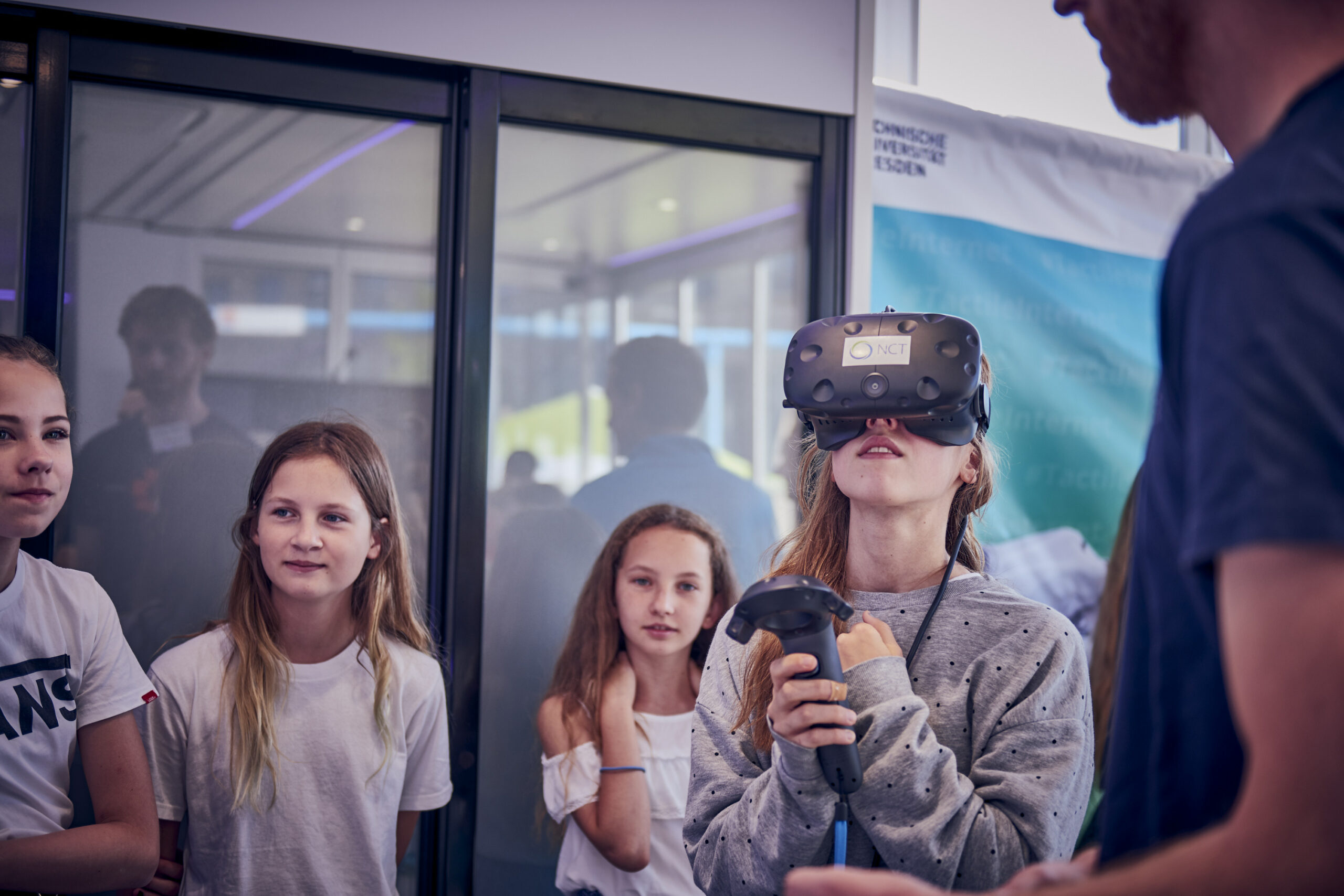 Four girls with a CeTI researcher, one girl is wearing a virtual reality visor and holding a controller